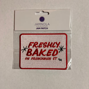 Embroidered patch with 'Freshly Baked' text with a red letters