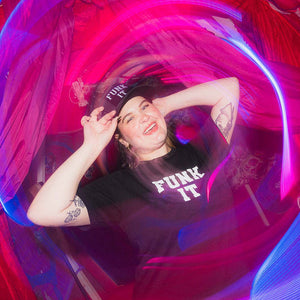 Person wearing a 'Funk It' shirt inside a colorful, swirling light tunnel.
