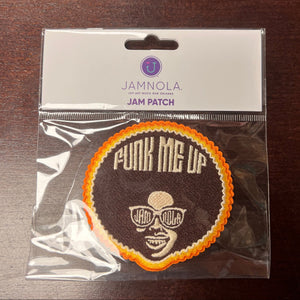 Patch with 'Funk Me Up' design in clear packaging on a dark surface