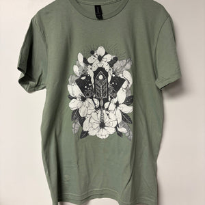 Green t-shirt with floral and geometric design on a light gray background
