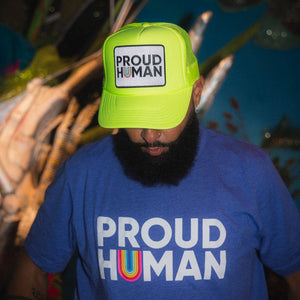 Person wearing a neon yellow 'PROUD HUMAN' truker and blue 'PROUD HUMAN' t-shirt.