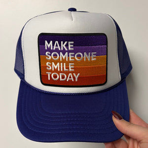 Purple cap with a message 'Make Someone Smile Today' on a white background