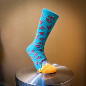 Sky Blue sock with red crawfish falling into a boiling pot with flames at the toes