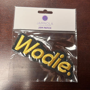 Packaged patch with 'Wodie' text on a wooden surface