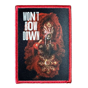 A patch featuring a Mardi Gras Indian with a red, white, and black color scheme, with the text 'WON'T BOW DOWN' on the top. The Indian is wearing a traditional red and black costume.